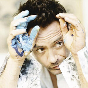 icon for Tayber. The icon shows Robert Downey, Jr. He is holding his paint-covered hands up to his head and looking to the right, away from the viewer.